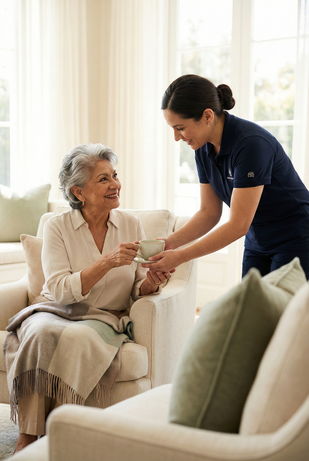 A Care Professional from allaround Concierge Care serving tea to a senior client at home in Miami.